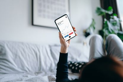 woman on phone looking at stocks app