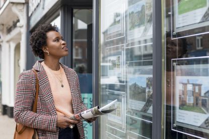 Woman looking into estate agent window